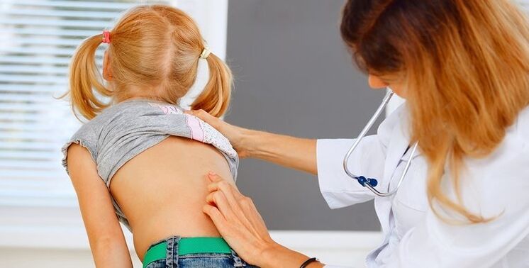 Doctor checks child's back for low back pain